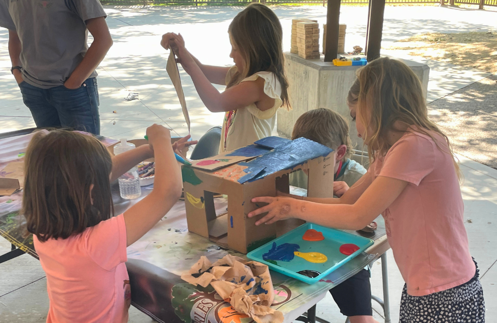 Children working together on a painting project at zoo camp for the animals.
